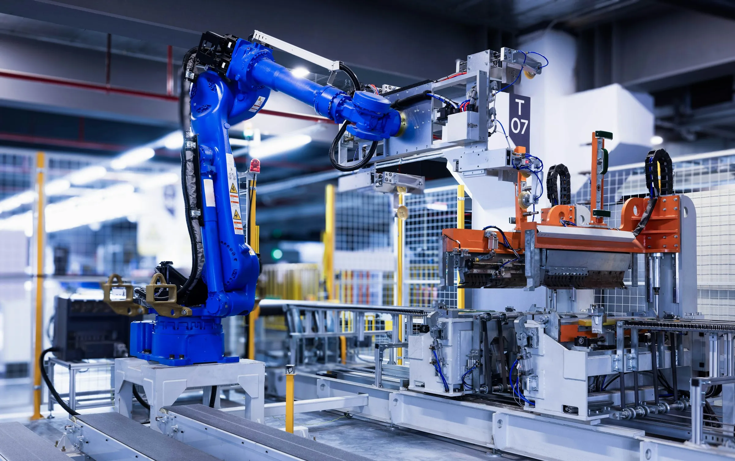 Industrieroboter an einer Fertigungsstation — SPS- und Roboter-Engineering durch HILA Automation.